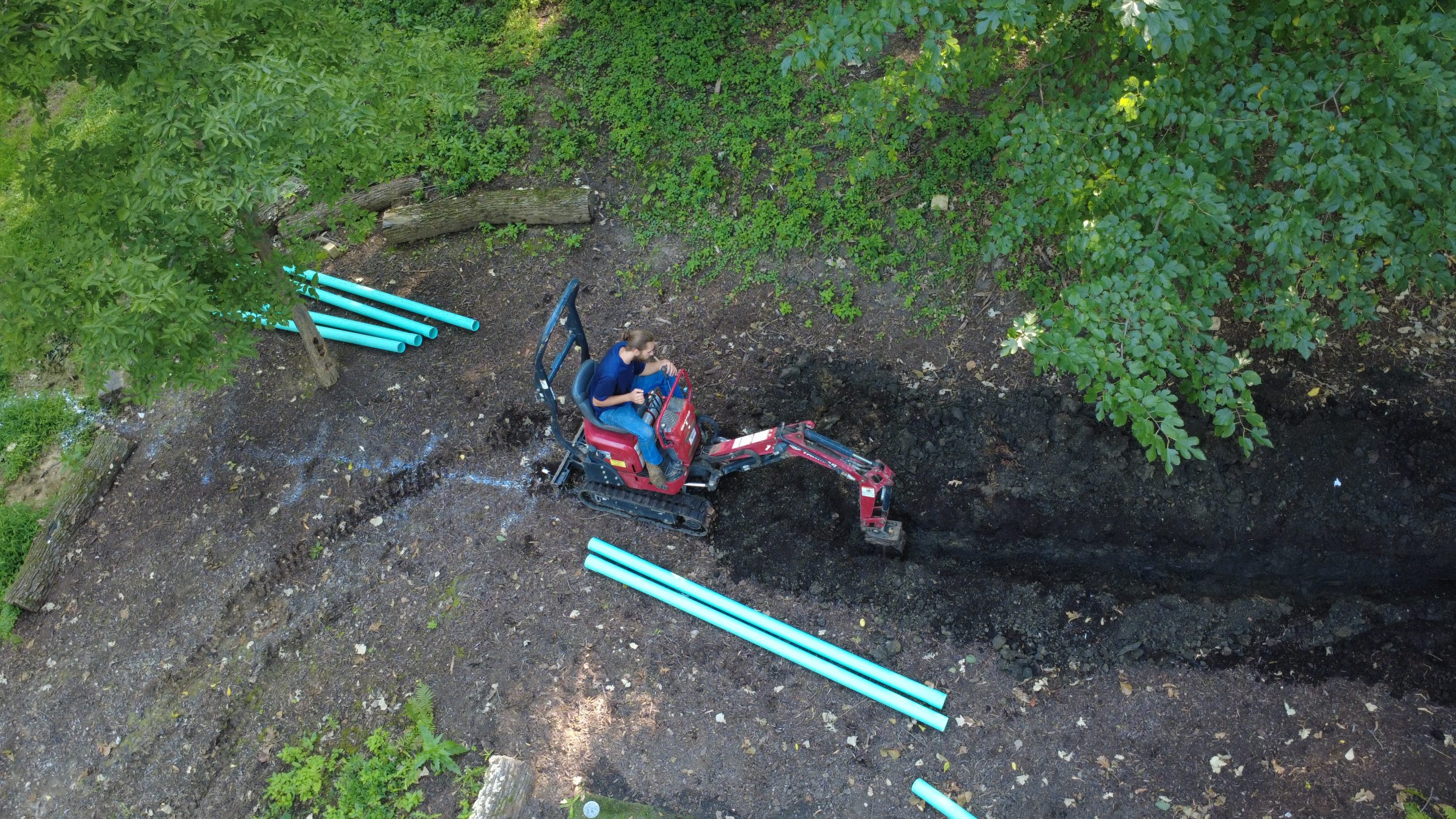 Mini excavator digging a sewer line trench